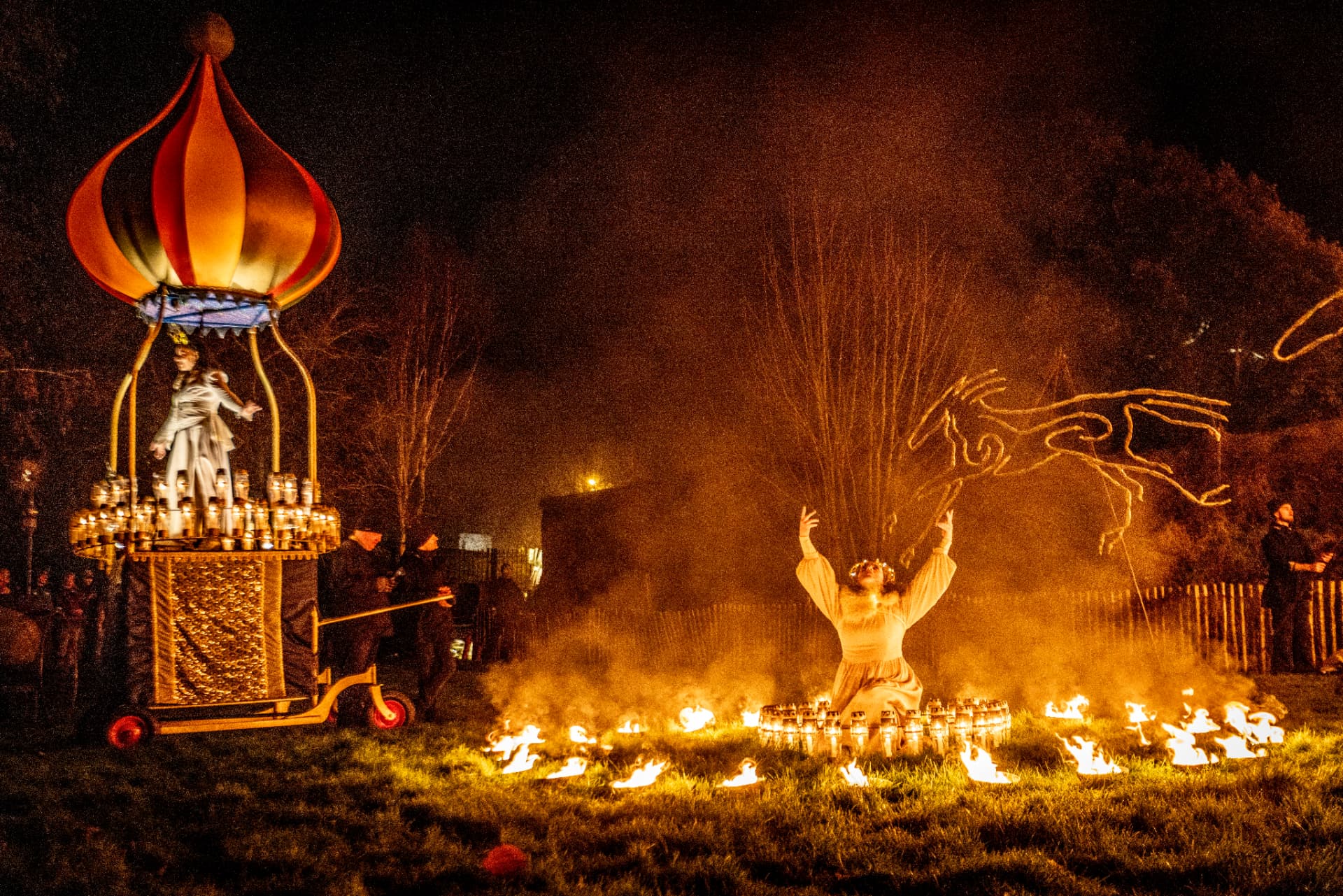 A festival performer surrounded by fire and a flame-shaped lantern